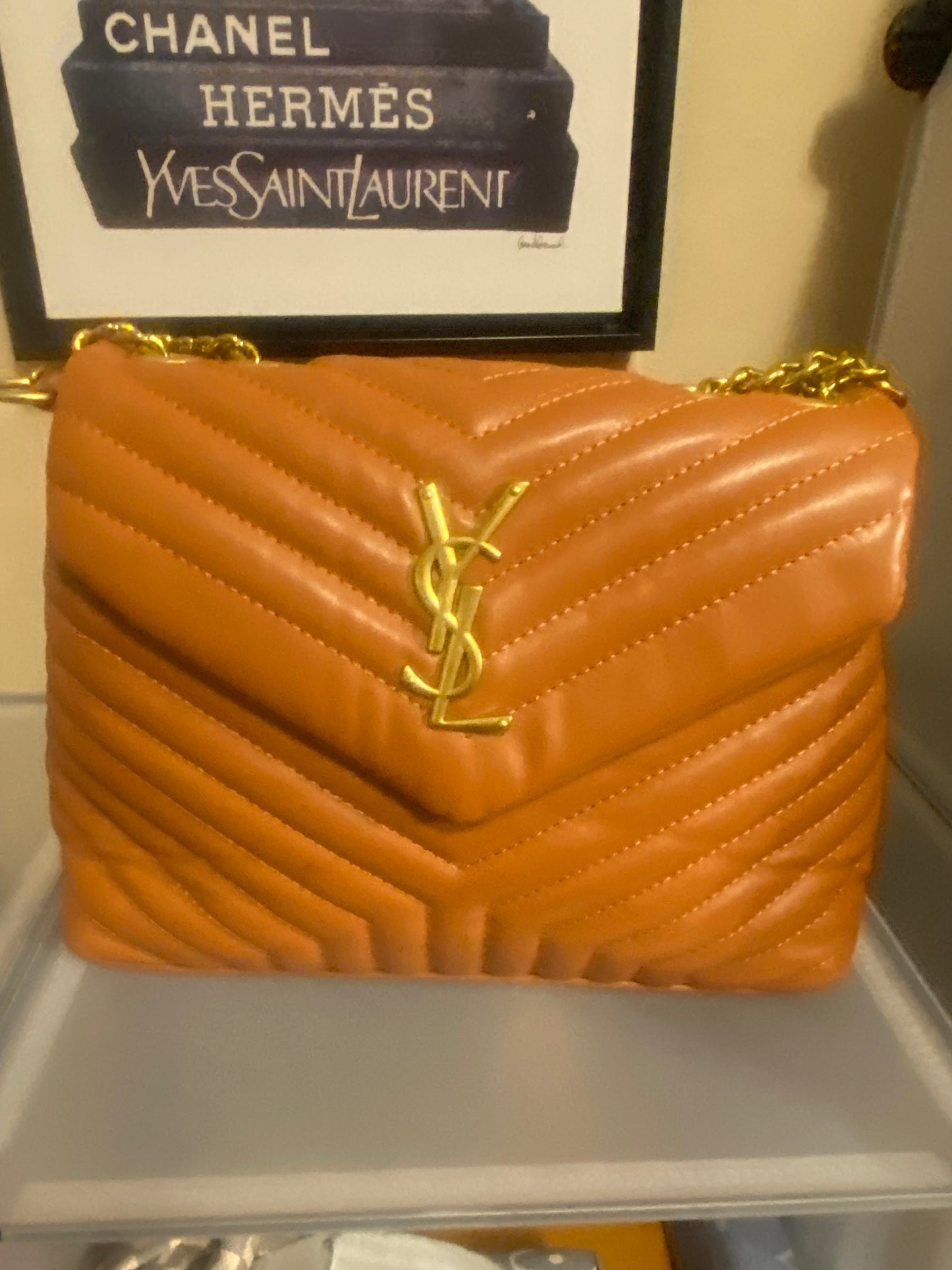 Orange YSL bag gold YSL in front of the bag