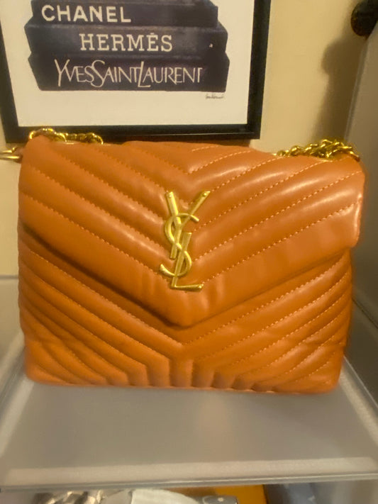 Orange YSL bag gold YSL in front of the bag